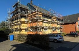 Außenaufnahme der noch eingerüsteten Fassade während der Sanierung. Die erneuerte Fassade ist bereits sichtbar.
