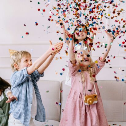Kinder die auf einer PArty mit Konfetti spielen