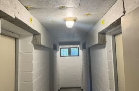 In dem weißgestrichenen Keller sieht man die Decke, welche mit einem hellgrauen Dämmmaterrial verkleidet wurde.